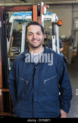 Hispanic worker smiling in warehouse Stock Photo