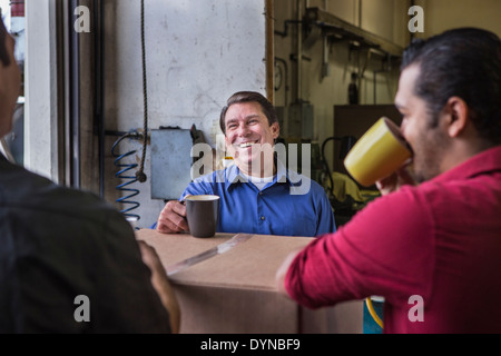 Workers enjoying coffee break in warehouse Stock Photo