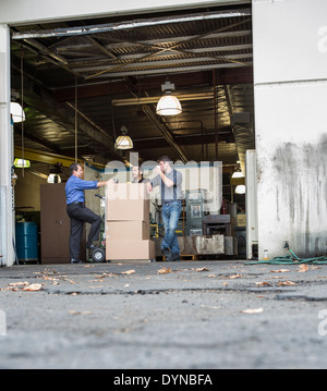 Workers enjoying coffee break at warehouse loading dock Stock Photo