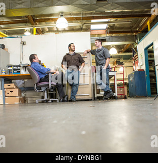 Manager and workers talking in warehouse Stock Photo