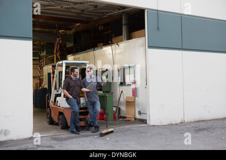 Workers using digital tablet at warehouse loading dock Stock Photo