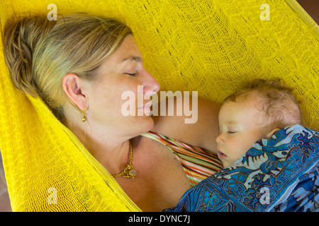 Caucasian mother and baby sleeping in hammock Stock Photo