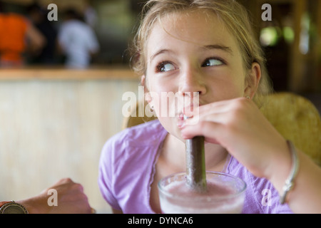 Caucasian girl drinking smoothie at breakfast Stock Photo