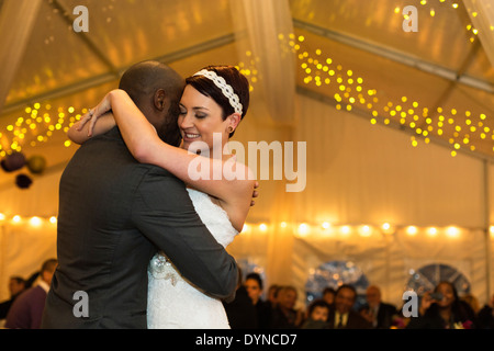 Newlywed couple dancing at reception Stock Photo