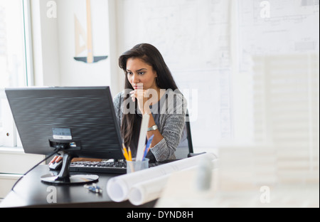 Hispanic businesswoman working in office Stock Photo