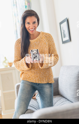 Hispanic woman using vintage camera Stock Photo