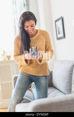 Hispanic woman using vintage camera Stock Photo