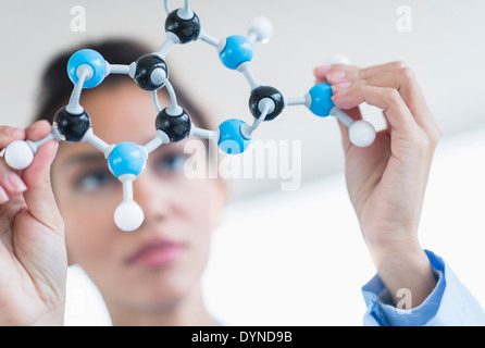 Hispanic scientist examining molecular model Stock Photo