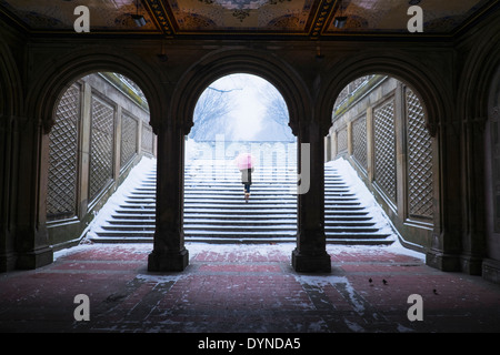 Asian woman walking up steps into snow Stock Photo