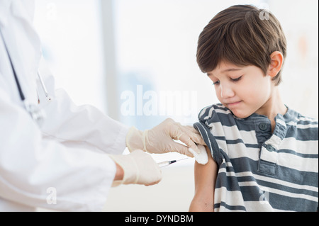 Hispanic boy getting a shot at doctor's office Stock Photo
