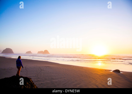 Caucasian woman overlooking sunrise on beach
