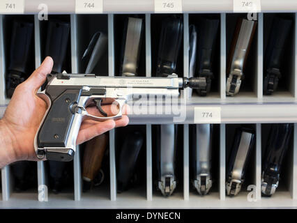 Rampe, Germany. 10th Apr, 2014. A police officer presents a 9mm PAK gas pistol at the armoury of the State Criminal Police Office (LKA) of Mecklenburg-Western Pomerania in Rampe, Germany, 10 April 2014. According to the current arms report of the German state Mecklenburg-Western Pomerania more than 21,000 citizens had a firearms license at the end of 2013. There are currently almost 80,000 guns, rifles, pistols and revolvers stored in private safes in the north-east of Germany. Photo: Jens Buettner /ZB/dpa/Alamy Live News Stock Photo