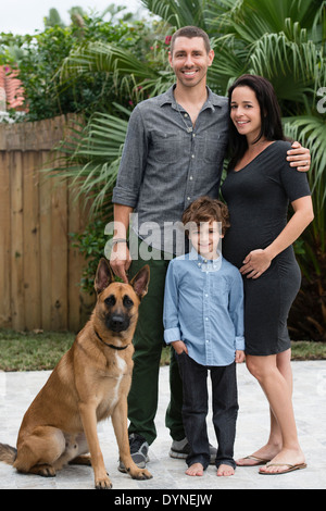 Family smiling together with dog outdoors Stock Photo