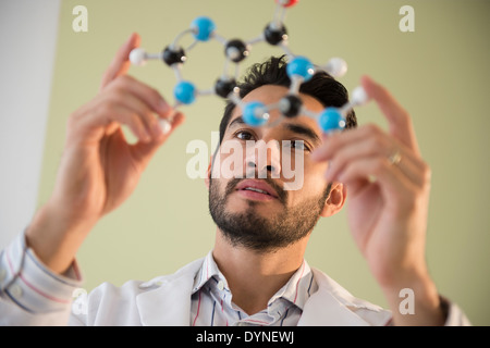 Mixed race businessman examining molecular model Stock Photo