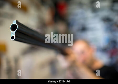 Rampe, Germany. 10th Apr, 2014. A police officer examines a combination gun used for hunting at the armoury of the State Criminal Police Office (LKA) of Mecklenburg-Western Pomerania in Rampe, Germany, 10 April 2014. According to the current arms report of the German state Mecklenburg-Western Pomerania more than 21,000 citizens had a firearms license at the end of 2013. There are currently almost 80,000 guns, rifles, pistols and revolvers stored in private safes in the north-east of Germany. Photo: Jens Buettner /ZB/dpa/Alamy Live News Stock Photo