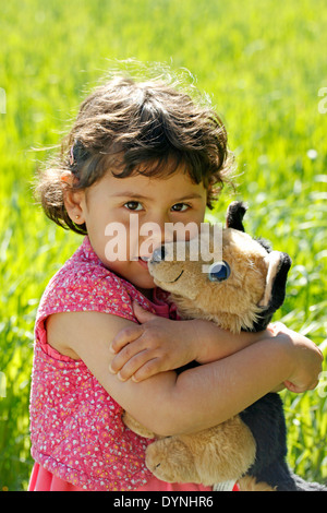 Little girl. 3 4 years old. Embracing her pet. Stock Photo