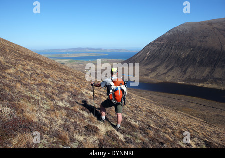 Walker on the slopes of the Cuilags the second highest hill on Hoy Orkney at 432m with Ward hill the highest hill at 481m Stock Photo