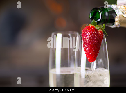 Pouring champagne into glasses for a romantic evening. Stock Photo