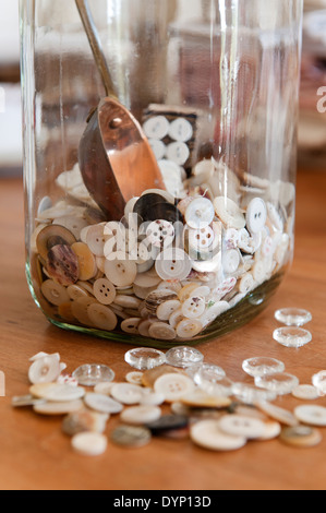 Buttons in and around a glass jar. Stock Photo