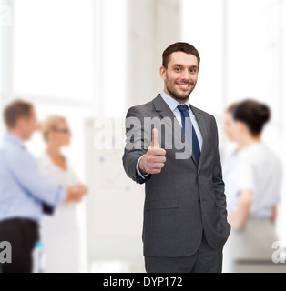 handsome buisnessman showing thumbs up in office Stock Photo