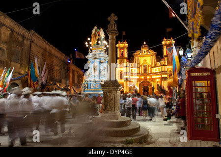 Locals fill up the town square to listen to the brass band during the annual parish feast in Gharb in Gozo in Malta. Stock Photo