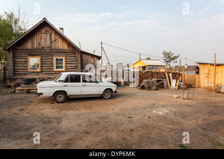 Wooden house and car on the yard in Khuzhir, Olkhon Island, Lake Baikal, Siberia, Russia Stock Photo