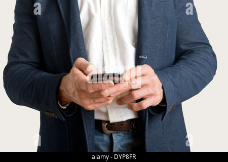 Casual businessman sending a text message on a mobile phone Stock Photo