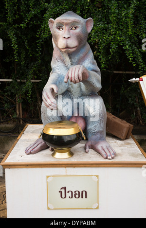 A monkey sculpture, Chinese zodiac animal sculpture at Wat Saket, Thai Temple, Thailand. a donation bowl sits below him. Stock Photo