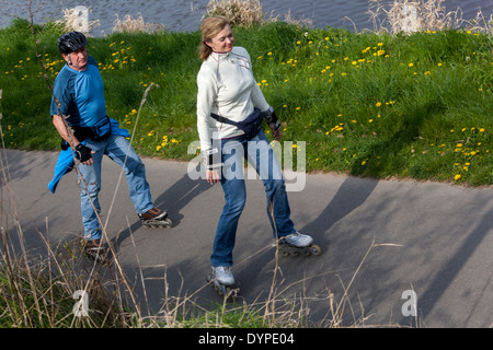 Active people use leisure time on roller skating on cycle trail Stock Photo