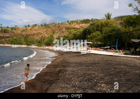The boats rest on the sandy beach of Amed, a fisherman village in East Bali. Amed is a long coastal strip of fishing villages Stock Photo