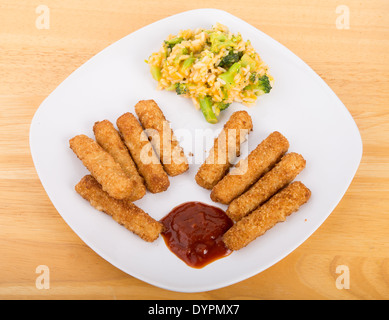 Crispy fish sticks on a white plate with broccoli cheese casserole and cocktail sauce Stock Photo