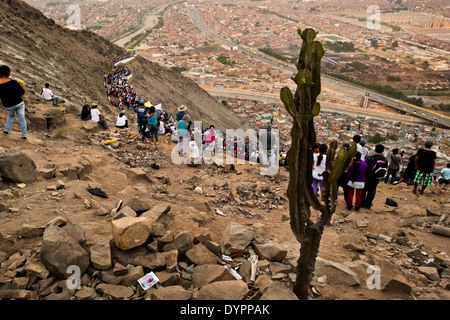 Crowds of catholic followers watch the Good Friday procession climbing the hill during the Holy week in Lima, Peru. Stock Photo