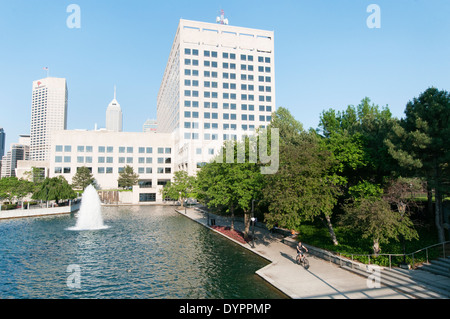 USA, Indiana, Indianapolis. A man cycles along the towpath of the central canal in downtown Indianapolis. Stock Photo