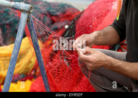 Fisherman Repairs Fishing Net Stock Photo