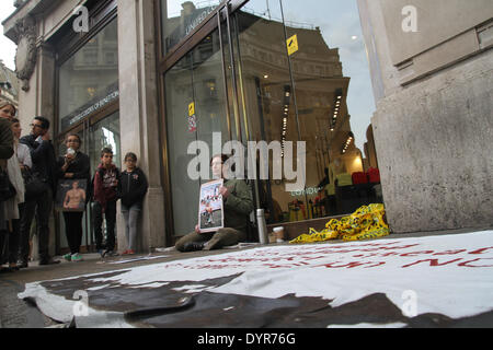 London, UK. 24th April 2014. A large banner seen between the two chained protesters outside The Benetton store on Oxford Street Credit:  david mbiyu/Alamy Live News Stock Photo