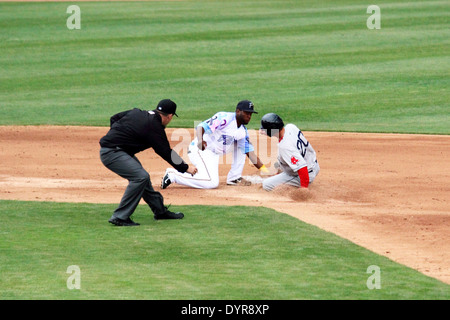 A runner slides into second attempting to steal second base. Stock Photo