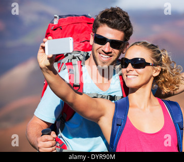 Happy couple taking photo of themselves with smart phone outdoors, Taking a 'selfie'