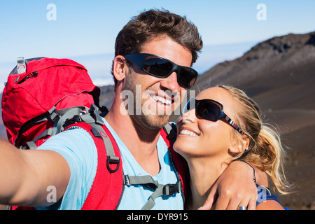 Happy couple taking photo of themselves with smart phone outdoors, Taking a 'selfie'