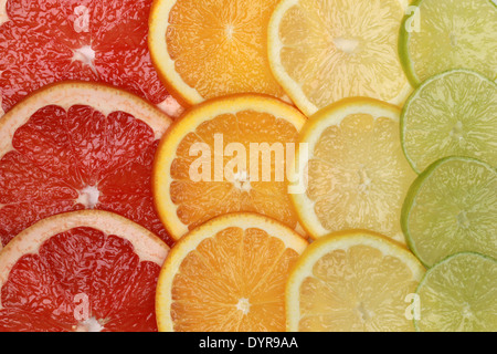 Sliced lemons, oranges, grapefruits and limes forming a background Stock Photo