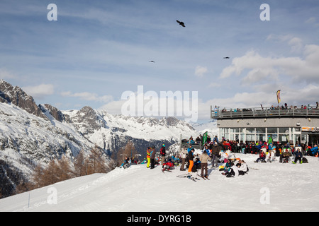 Skiers bask in the sun at the Lognan restaurant area, the halfway point to the top of Grands Montets. Stock Photo