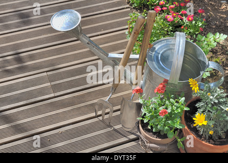 flowers pots and gardening tools on a wooden terrace Stock Photo
