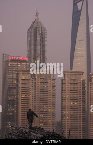 A worker stand on scrape metal at a construction site at the Bund with Pudong Financial district in background Stock Photo