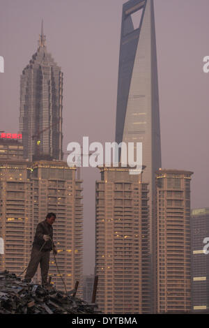 A worker stand on scrape metal at a construction site at the Bund with Pudong Financial district in background Stock Photo