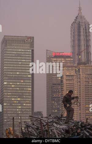 A worker stand on scrape metal at a construction site at the Bund with Pudong Financial district in background Stock Photo