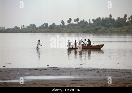 A Sudanese man walks to a boat in the Nile River just north of Khartoum. Stock Photo
