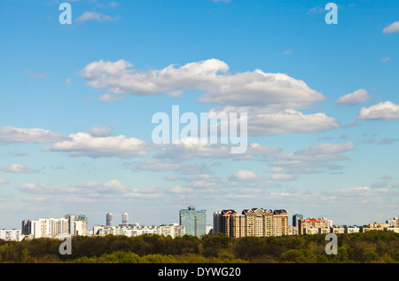 blue spring sky with white clouds over urban residential district Stock Photo