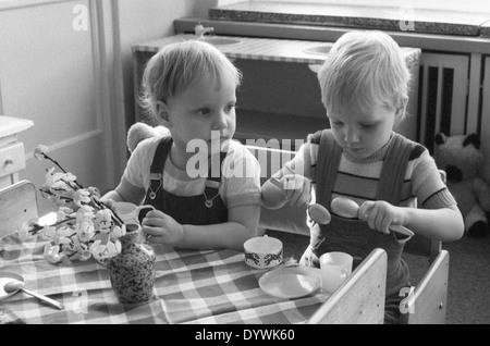 Berlin, DDR, Toddler sitting in kindergarten to eat at a table Stock Photo