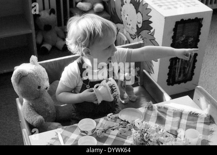 Berlin, DDR, toddler sits in kindergarten to eat at a table Stock Photo