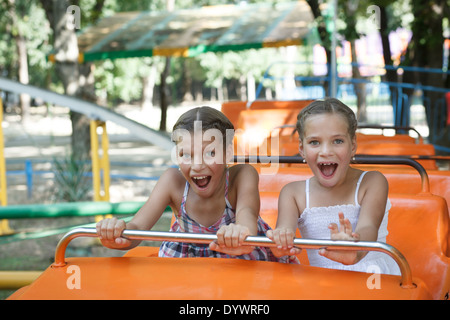 Portrait of happy sisters enjoying themselves on carousel Stock Photo