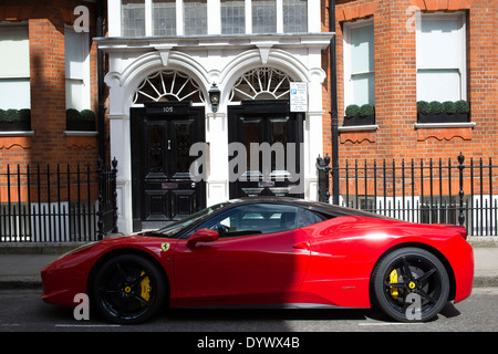 Red Ferrari supercar parked near Sloane Square in Chelsea. Wealth in London, UK. Stock Photo